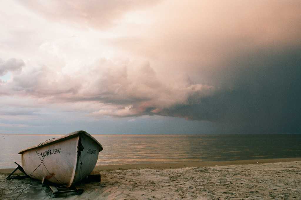 rowboat on shore with dark cloudy sky