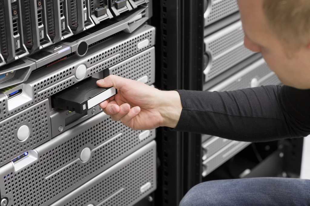 It engineer inserts backup tape 167242245