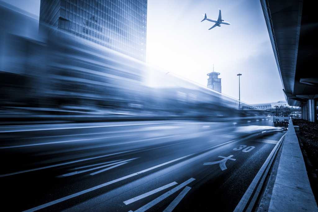 airplane flying over car in motion