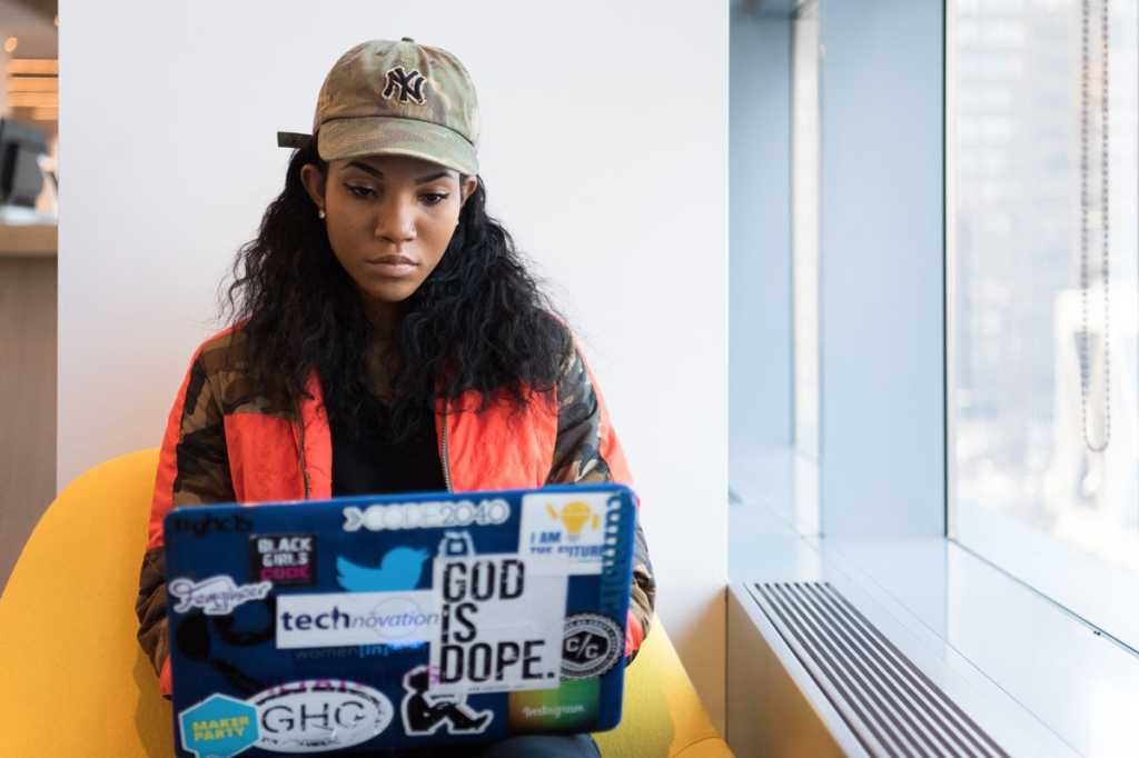 african american woman with laptop with stickers diversity gender equality programmer by christina