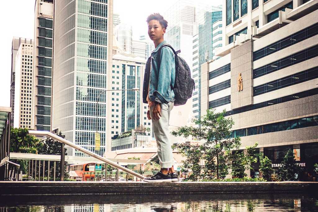 young man / student stands in a city street / next generation / Singapore
