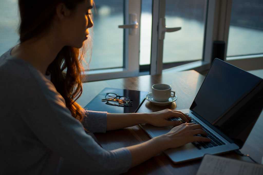 woman ising a laptop / workspace / coder / developer / hacker / programmer
