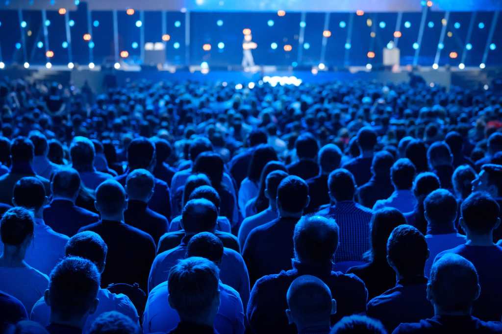 audience listens to speaker lecture at a conference presentation
