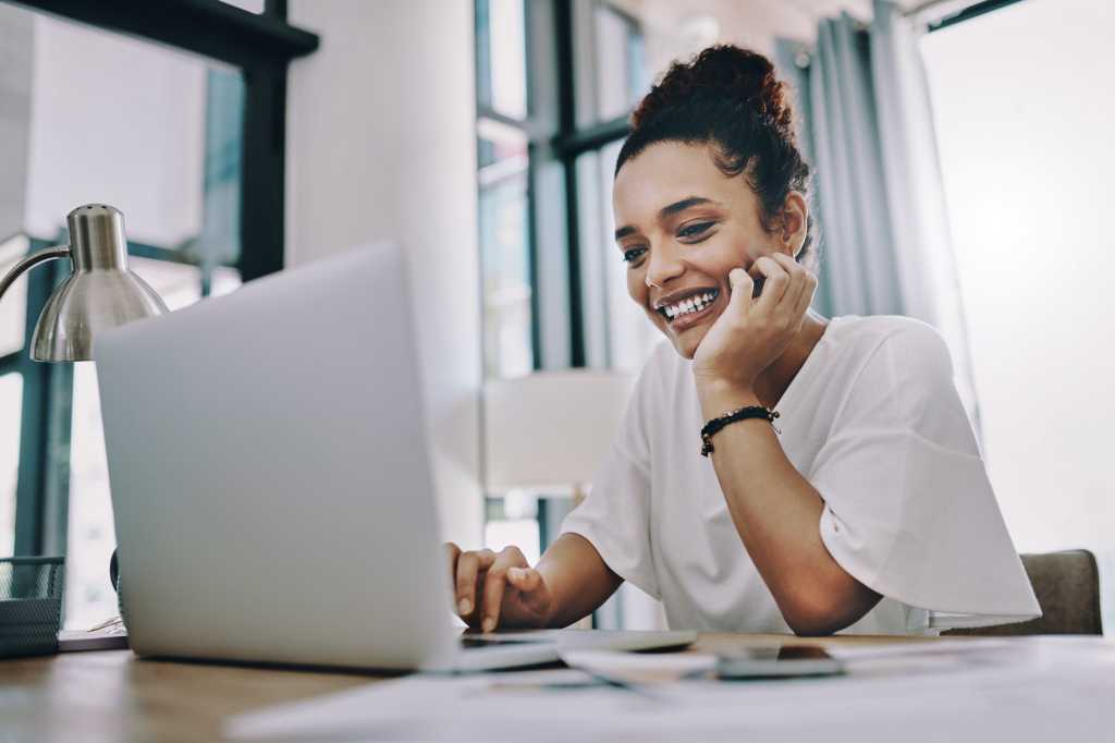 woman smiling in front of laptop