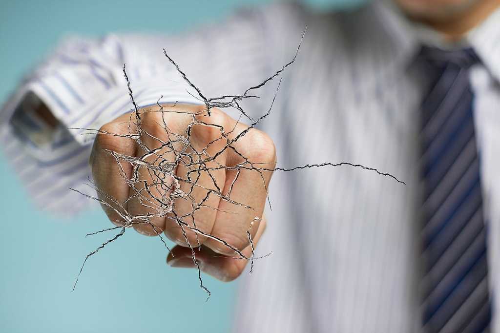 businessman's fist breaking through a barrier