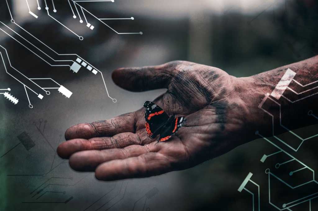 digital transformation / butterfly in a work-worn hand amid abstract circuitry