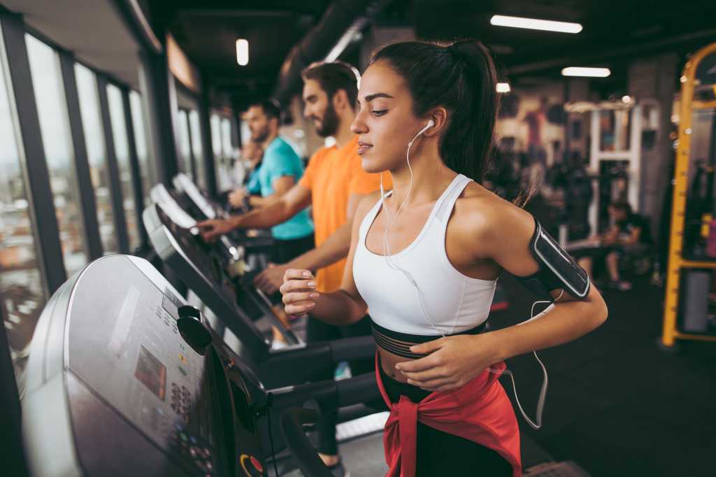 Young woman exercising on treadmill [health club, gym, training]