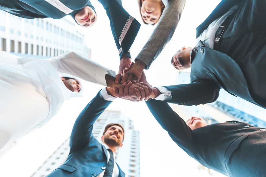 CIO | Middle East > Joining hands / huddle / all hands in / teamwork / collaboration / partnership