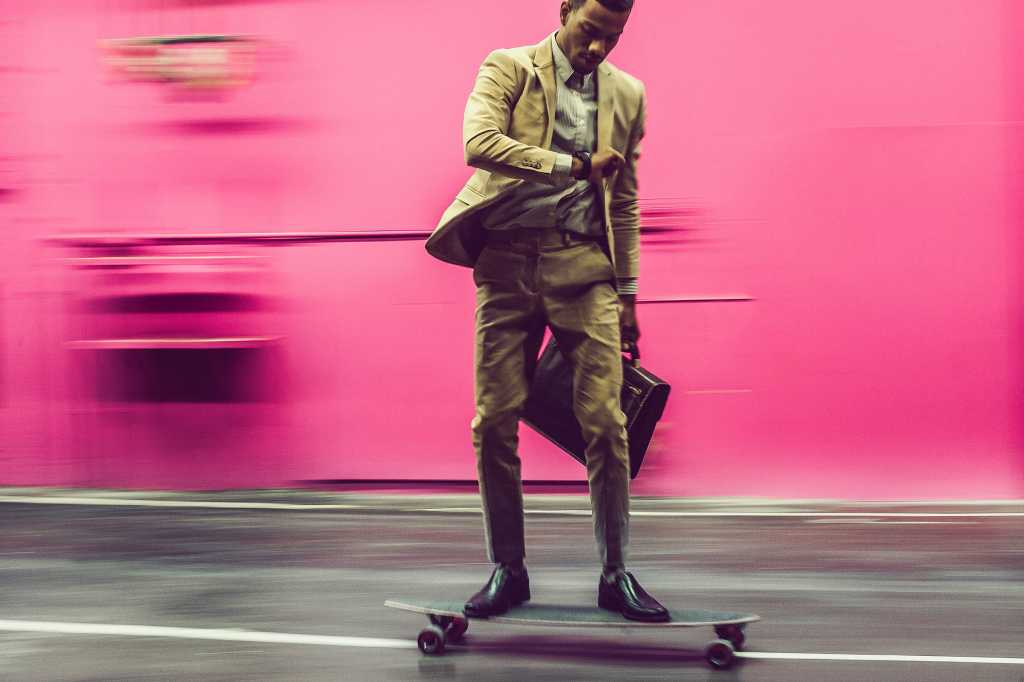 businessman on a skateboard, looks at his watch / motion / time / speed / transition / impermanence
