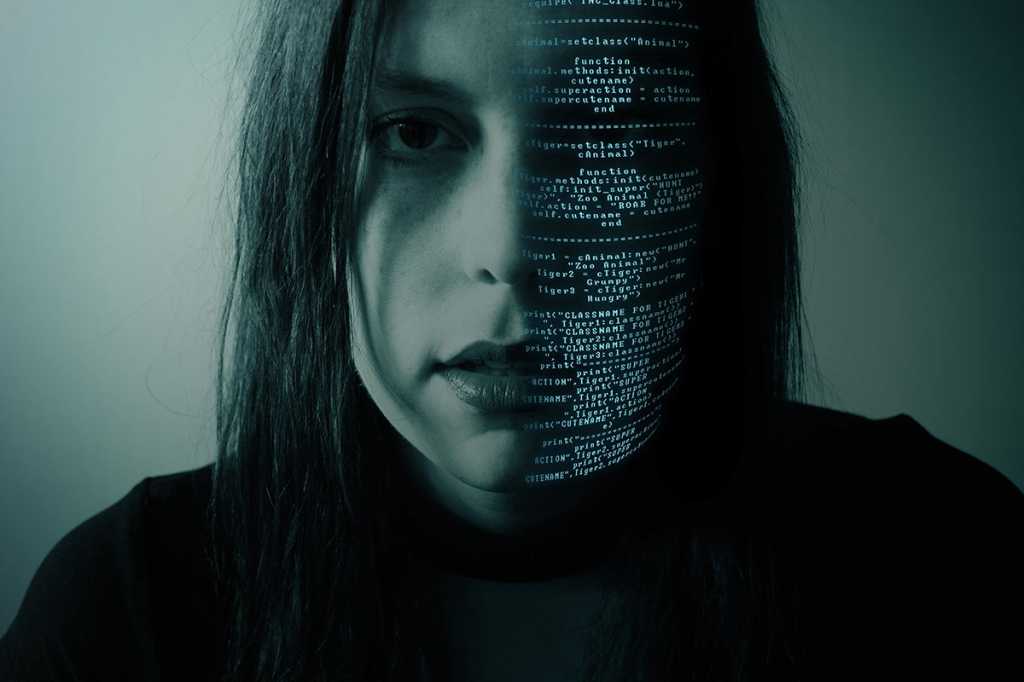 woman in darkness with half of her face in code