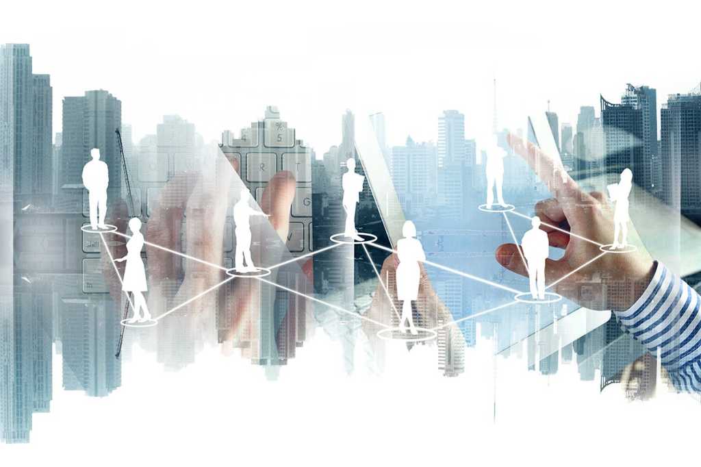 multiple-exposure image showing a network of people and tools [keyboard, tablet] against a skyline