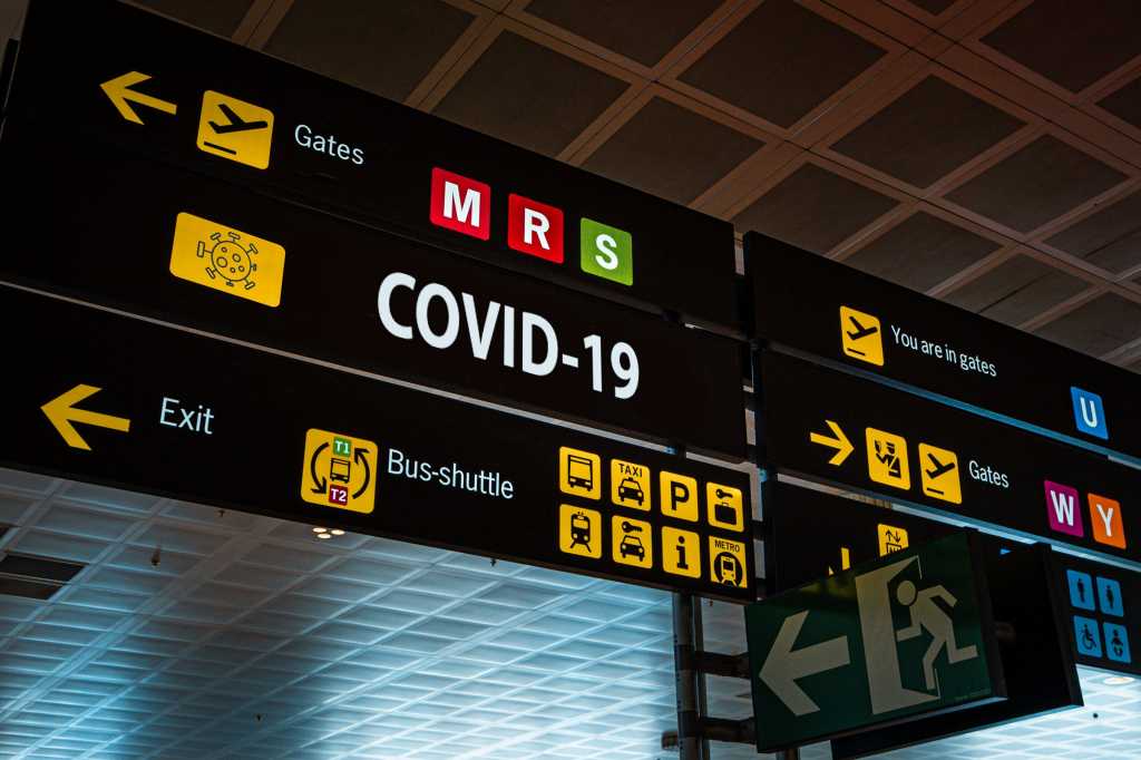COVID-19 coronavirus signage on airport flight displays. / pandemic / directions / guidance