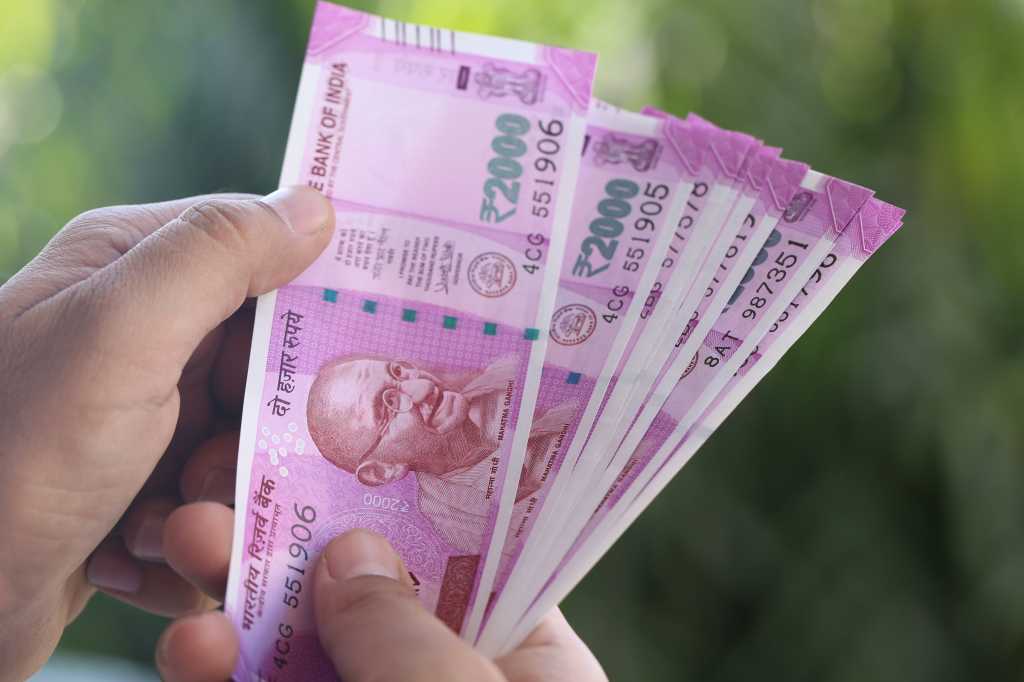 hand holding indian currency rupee currency fanned gandhi by triloks gettyimages 624968430.jpg