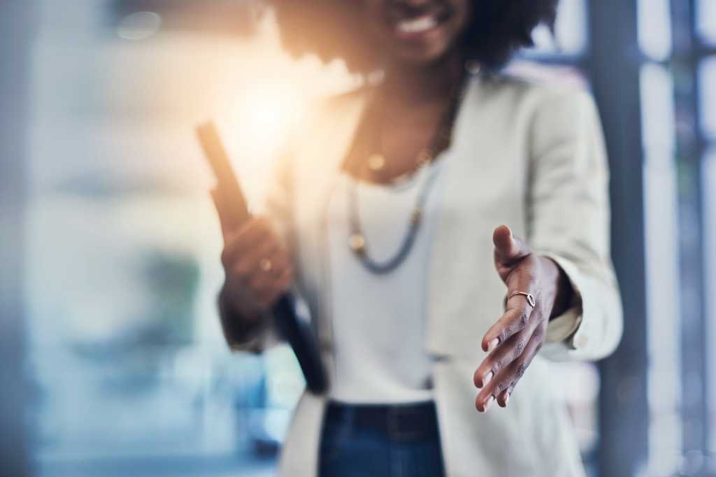A woman extends her hand in greeting / agreement / partnership / teamwork / hiring