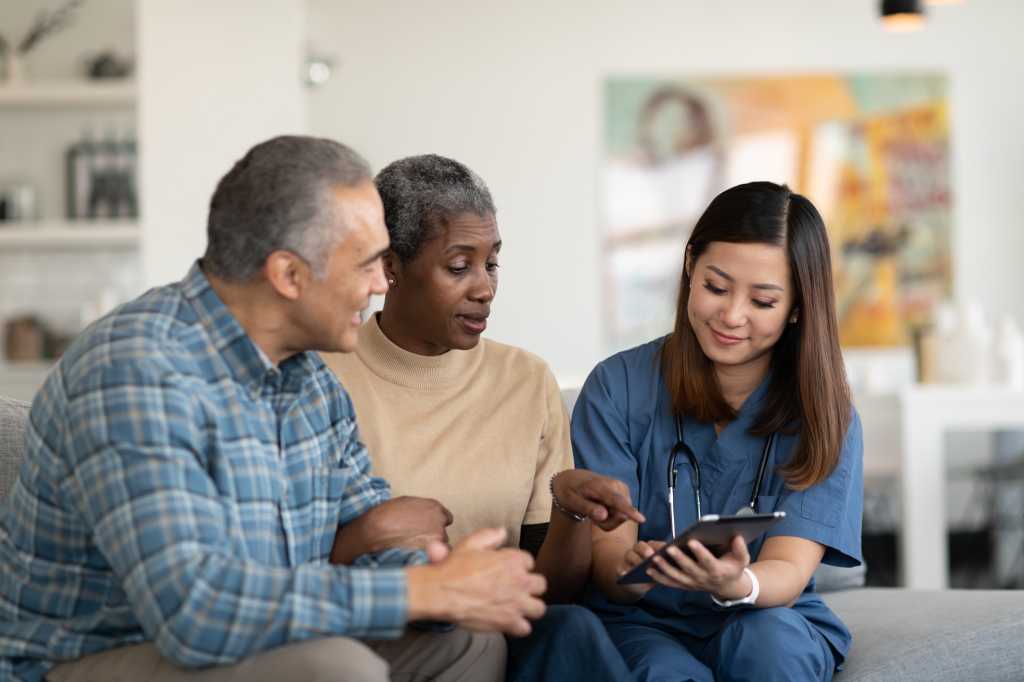 Nurse assisting patient on iPad.
