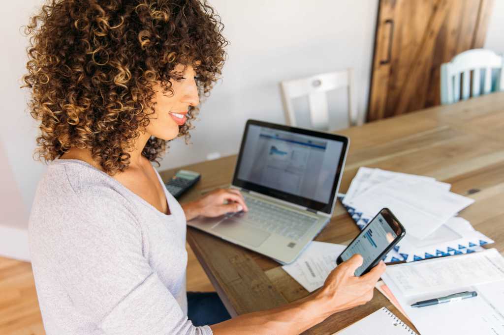 Woman multitasking on computer and smart phone