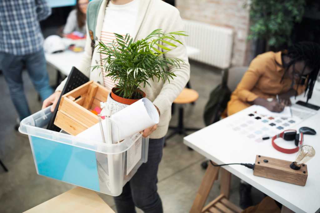 Woman walking out with a box full of stuff