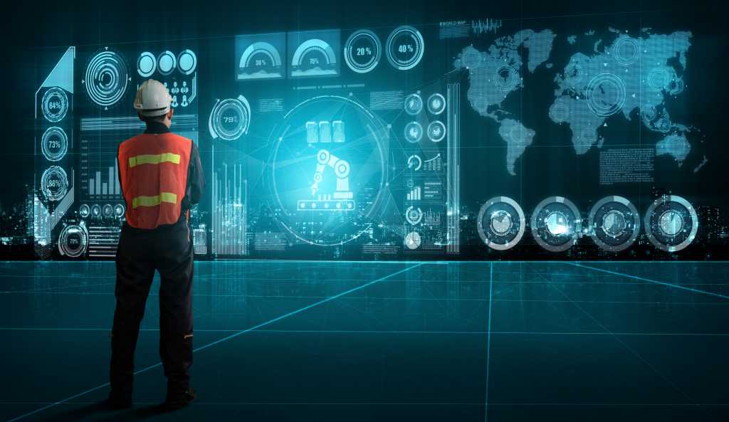 Man in hard hat looking at a large data screen