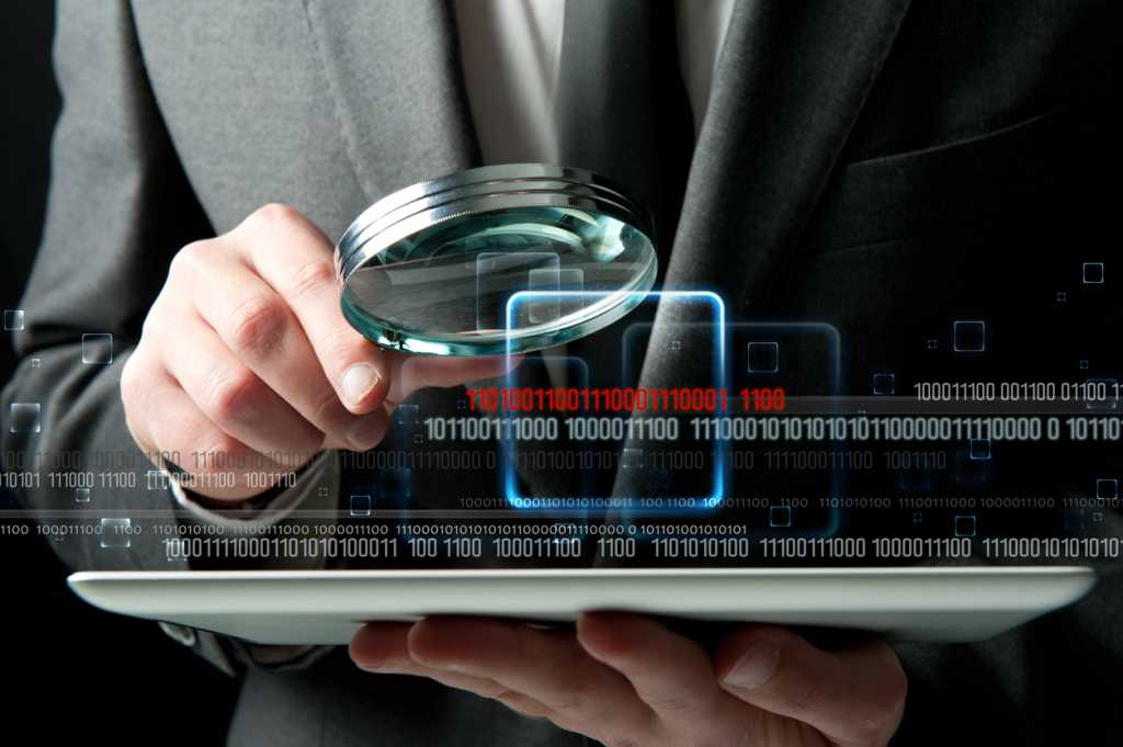 Businessman looks for the malicious code of a virus