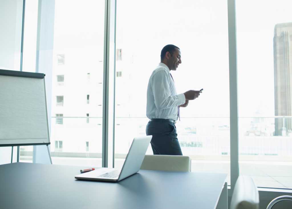 man at office looking at phone