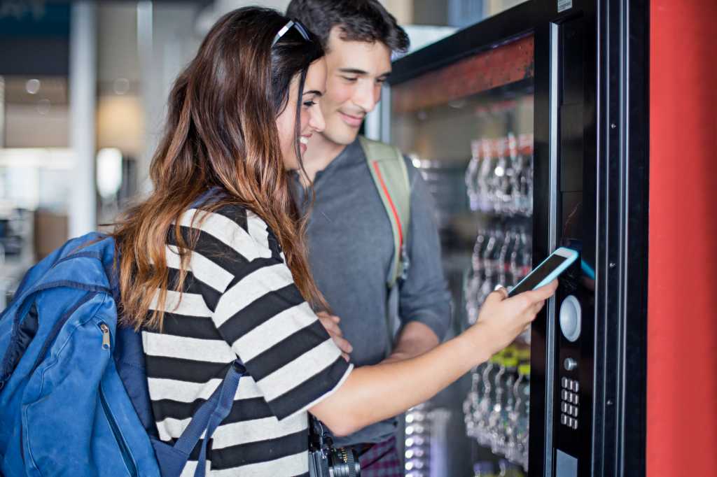 Couple paying vending machine with mobile phone
