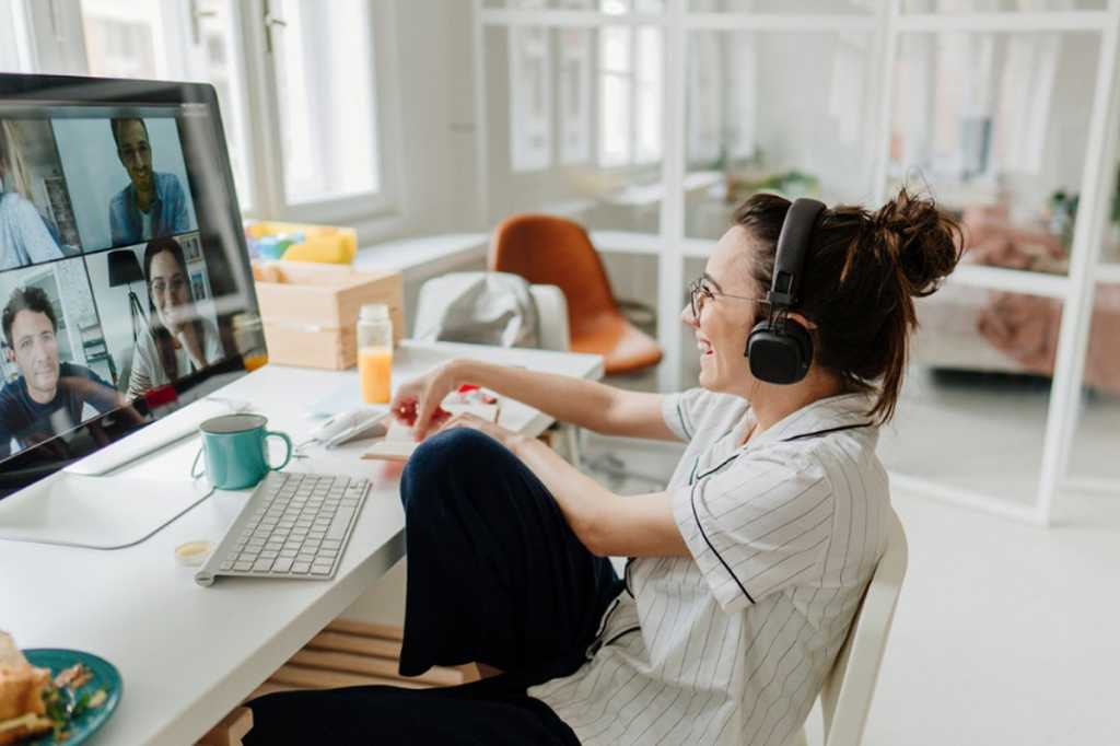 Smiling lady sitting on conference call using headphones