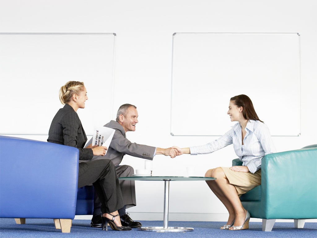 man and women executives sitting in office shaking hands and interviewing