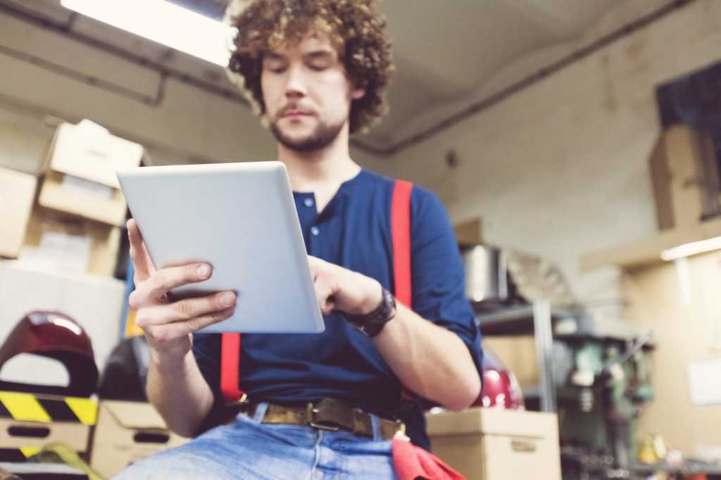 man in a workshop using a digital tablet 000091629367 medium