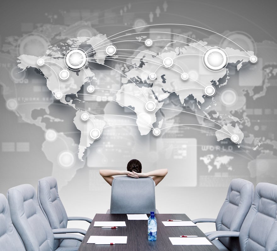 man in conference room looking at world connectivity