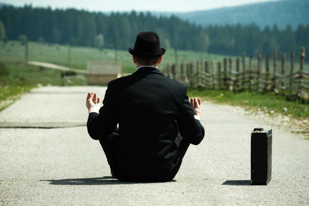 man in yoga position mediation relax briefcase stress