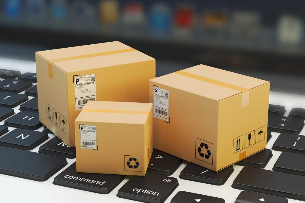 Three miniature packages sit on a computer keyboard.