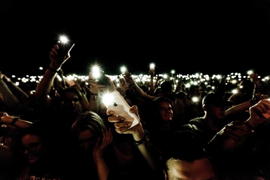 mobile phone lights held up in tribute to memorialize, commemorate, honor or remember