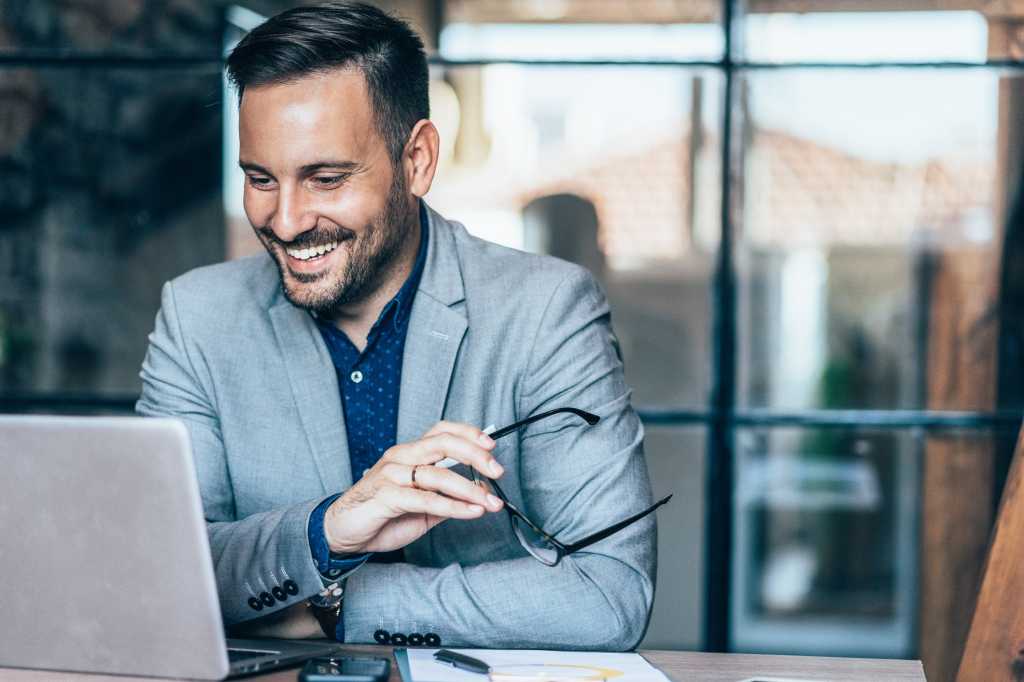 businessman looking happy in front of laptop