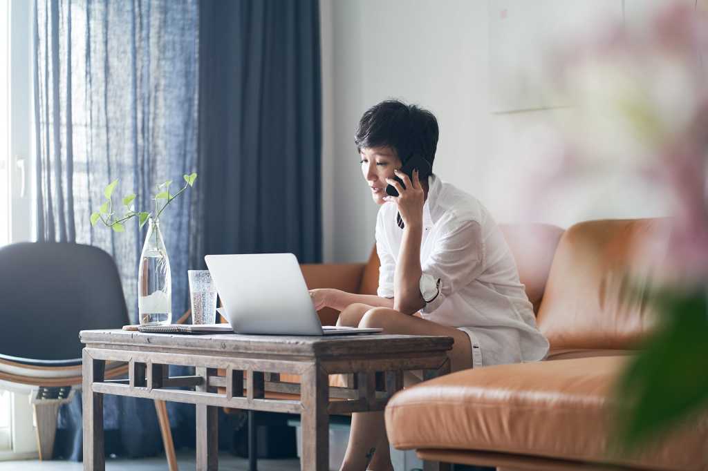 A woman works remotely on her laptop.