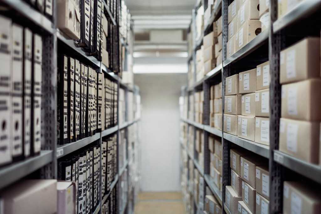 library / repository / binders and boxes on shelves in a large archive
