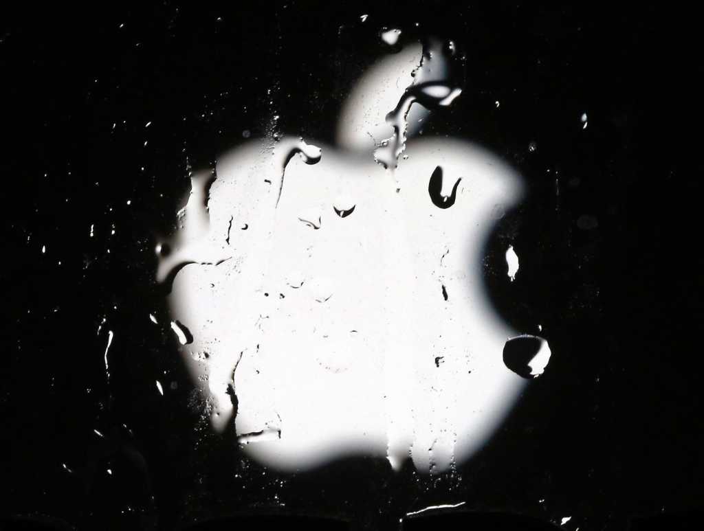 Abstract Apple logo behind rainy glass