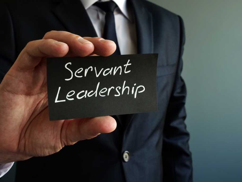 Servant leadership concept. Black piece of paper in the hands