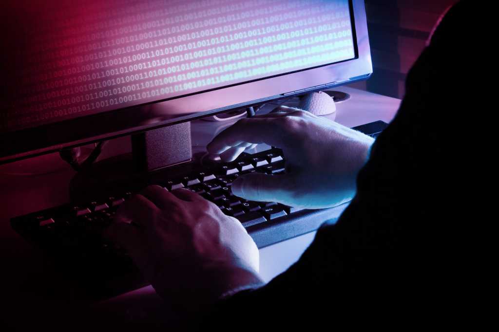 Tech Spotlight   >   Cybersecurity [IFW]   >   Hands at a keyboard with binary code on the display.