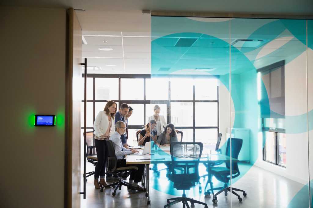 stock photo business people huddled around conference table 95171255 1