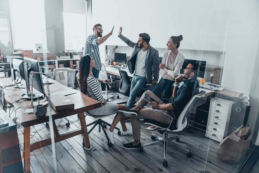 successful team collaboration shows happy employees celebrating and giving each other high fives