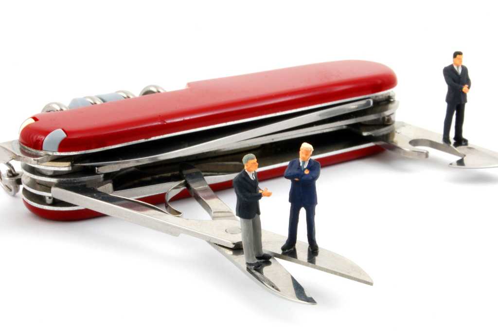 red swiss army knife with miniature business men