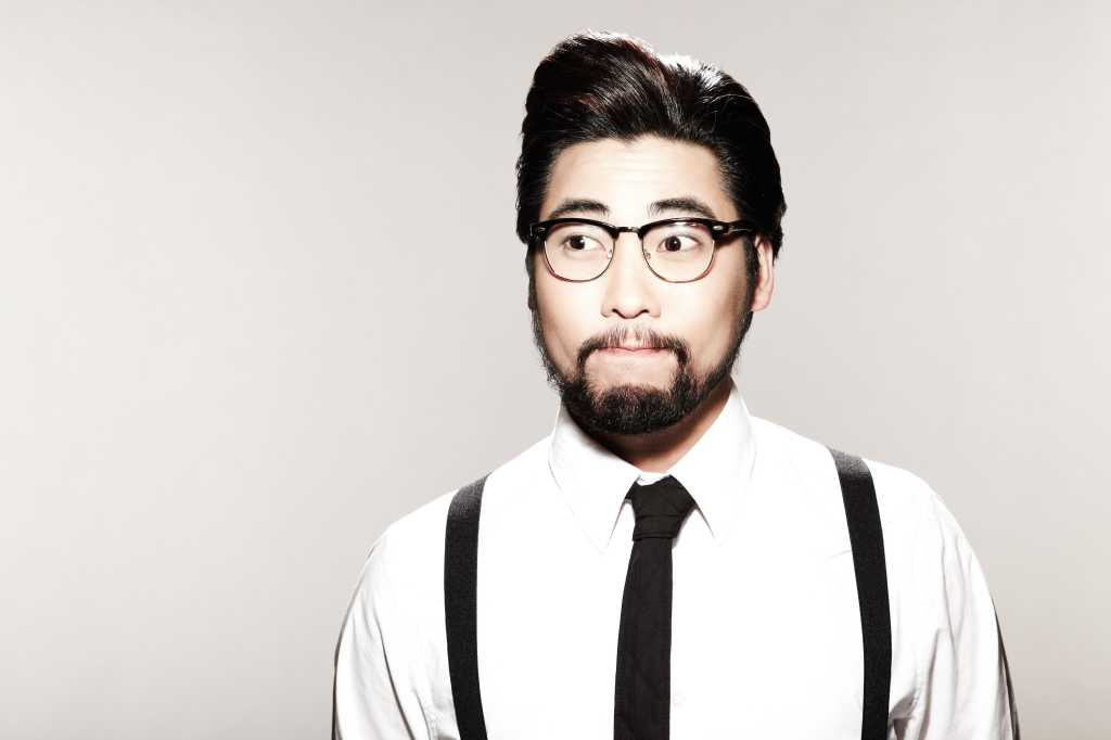 Young asian hipster in suspenders looking surprised or confused