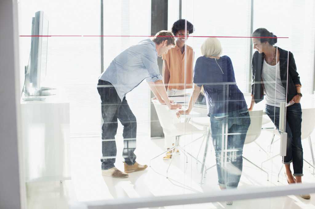 Group of people huddled around office table
