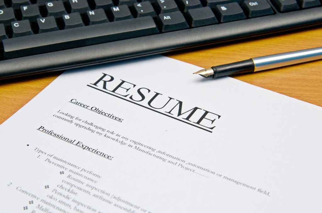Resume with pen and laptop on desk