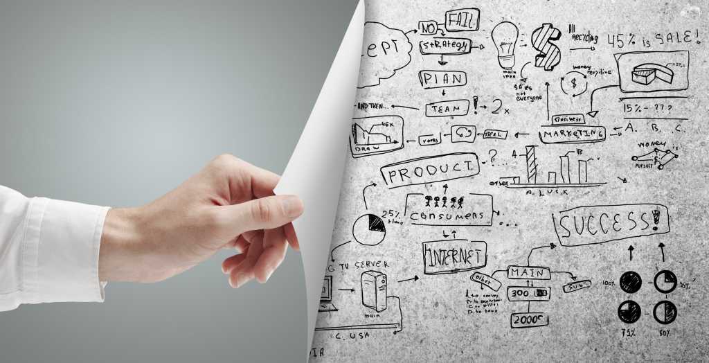 Hand uncovering paper with sketched diagrams beneath