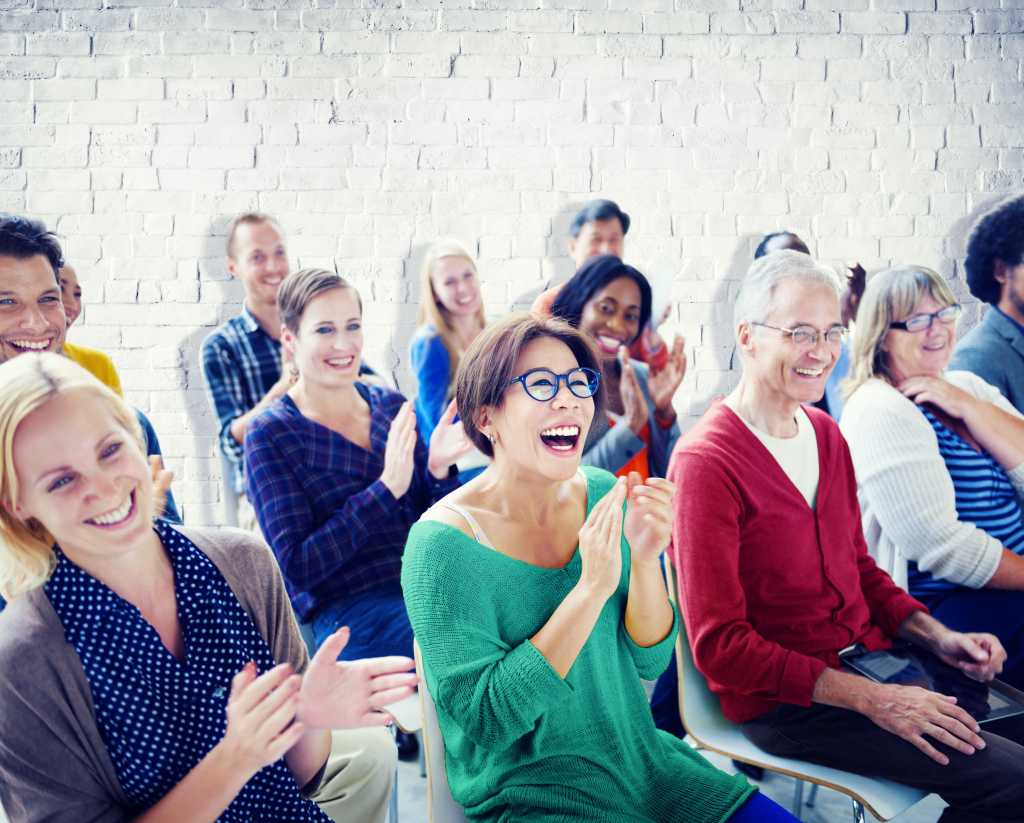 Group of diverse people in an audience looking happy