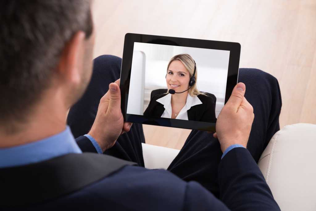 Man in suit videoconferencing on tablet