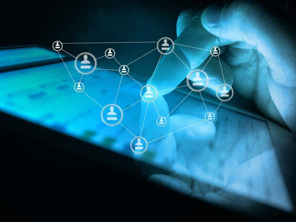 Glowing hand using tablet with floating apps