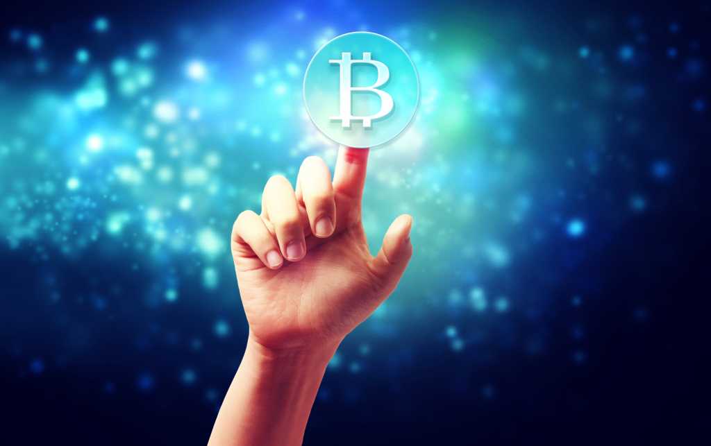 Hand pointing at bitcoin in virtual background