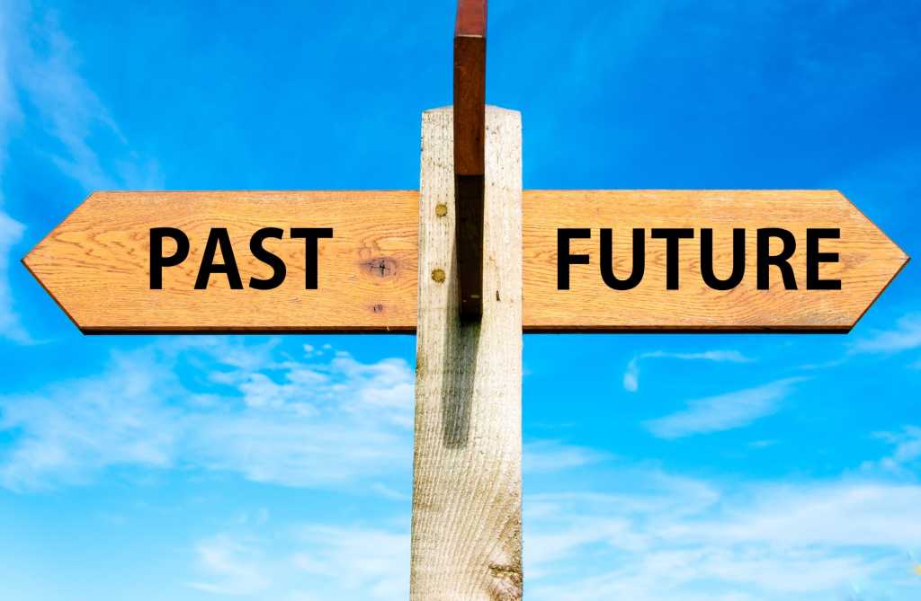 Wooden street sign with past and future going in two directions